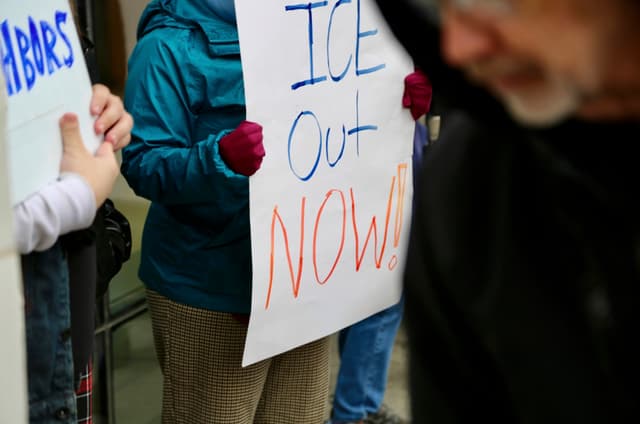A handmade 'ICE Out Now!!' sign held at a demonstration